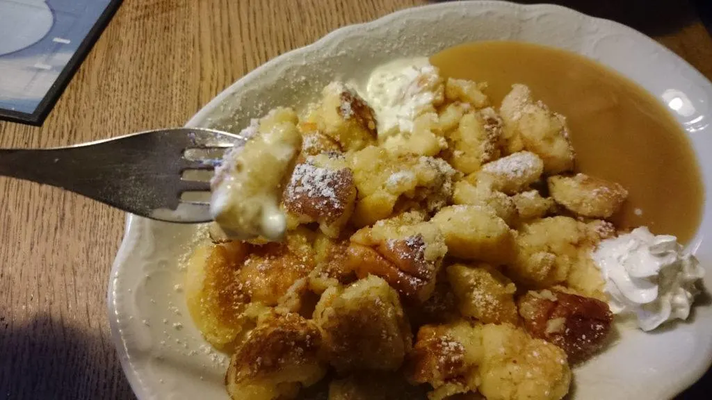 Kaiserschmarrn 1 person serving on a plate with applesauce and whipped cream.