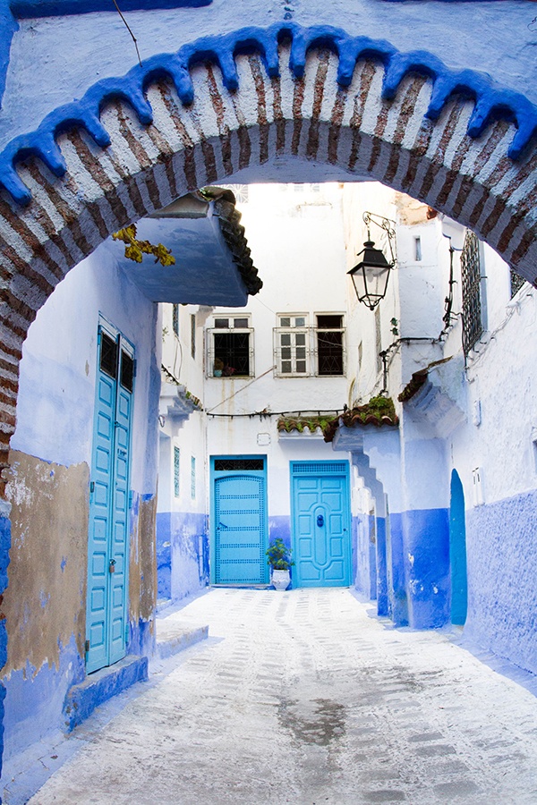 An archway into another blue Chefchaouen street.