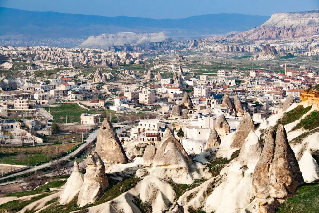 The beautiful town of Goreme, the center of Capadocia, is a mix of white buildings with red roofs and volcanic pillars.