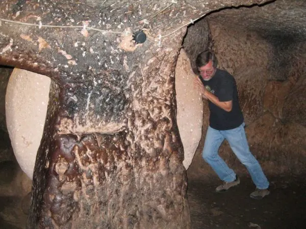 A visitor rolls a huge disc-shaped stone door in the underground city of Derinkuyu in Turkey.