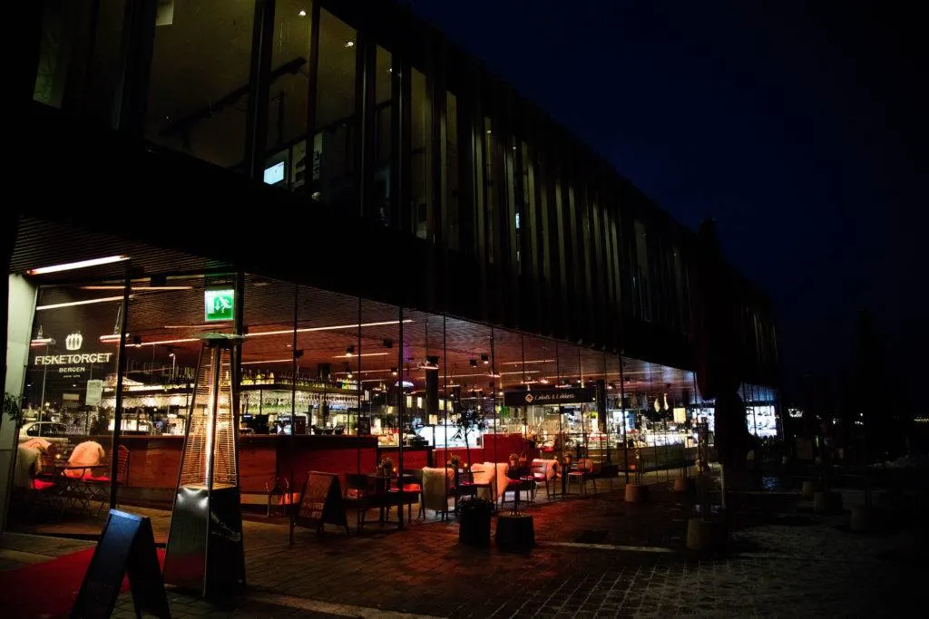 A restaurant at the Bergen Fish Market lit up at night.