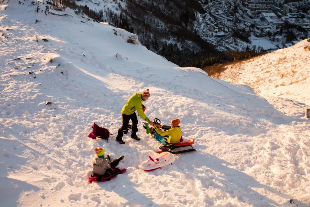 A family sledding in the afternoon light. It’s a popular winter activity in Bergen.