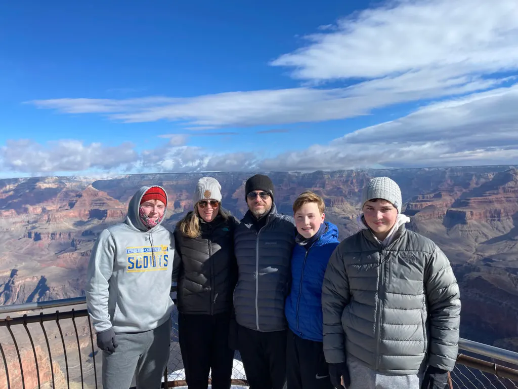 A family photo posed in front of the Grand Canyon.