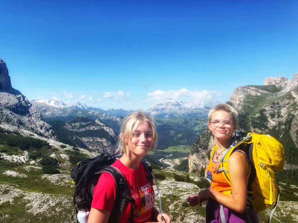 Two girls enjoy the view while they walk the Dolomites.