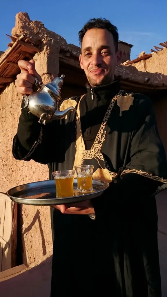 Moroccan tea cafe, man pouring tea at the Ksar of Ait Benhaddou.