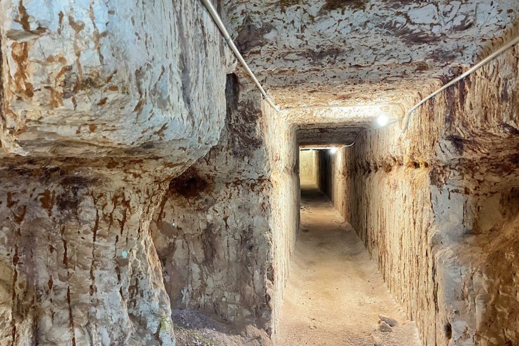 A tunnel in Quest Mine in Coober Pedy. The walls are naturally white with reddish-brown streaks.