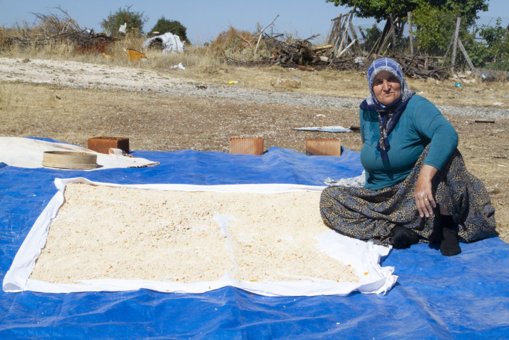Woman drying breadcrumbs to make Tarhana soup.