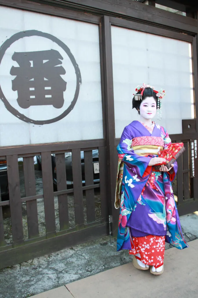 A maiko poses in Asakusa neighborhood, a great place to visit in Tokyo.
