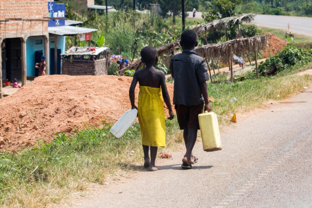 Kids walking on the road to go to the well. Driving in Uganda is full of surprises.