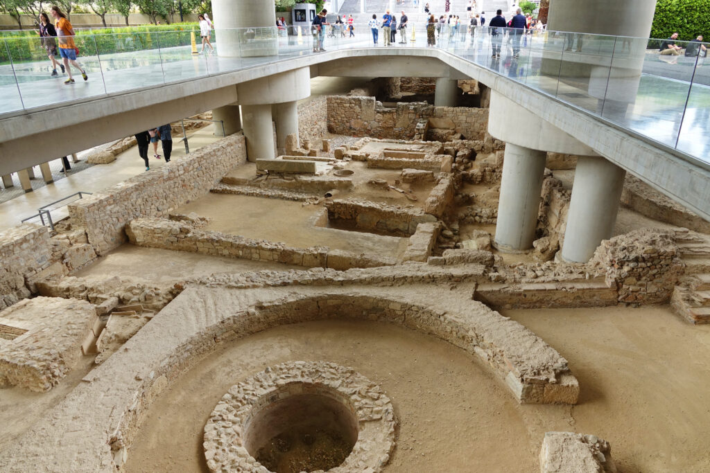 The Acropolis Museum entrance begins with a walkway overlooking the ruins of an ancient Athenian neighborhood.