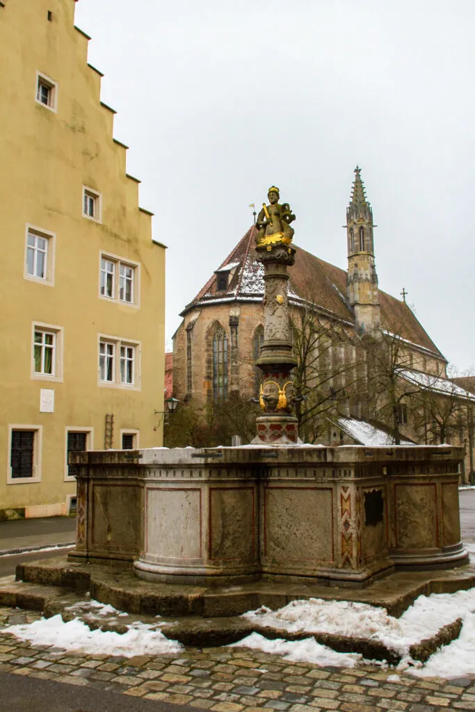 The Lord's fountain in winter doesn't have water, but it's still a must-see attraction in Rothenburg.